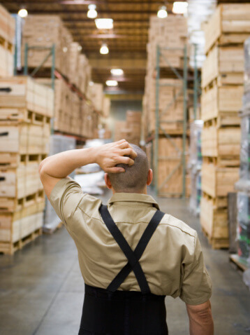 Warehouse worker looking for product in aisles